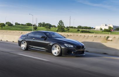 An elegant black car cruising along a scenic grassland