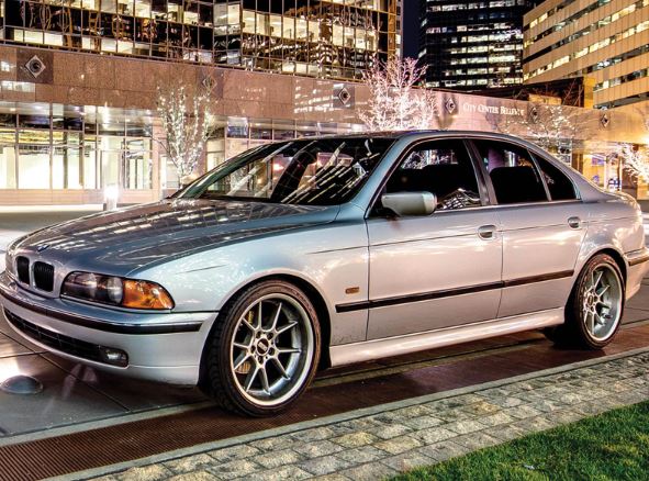 A fancy BMW car parking in front of some office buildings