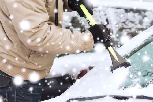starting up an ice-cold car - scraping ice off car windshield