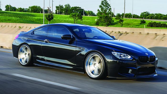 black cadillac driving down road